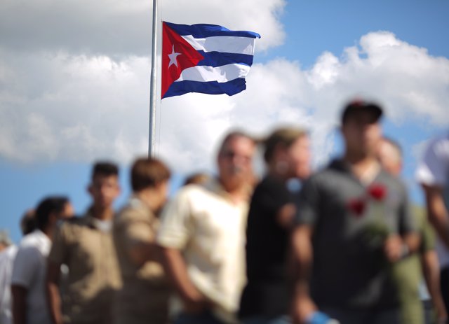 Bandera de Cuba mientras ciudadanos se despiden de Fidel