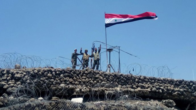 Soldados izan la bandera de Siria tras tomar una colina en Quneitra