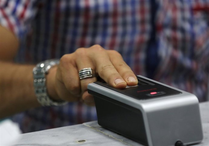 Un hombre deja sus huellas dactilares para conseguir un carnet rebelde