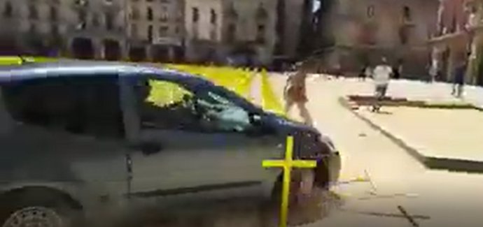 Un coche embiste las cruces amarillas plantadas en la plaza Major de Vic