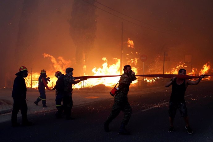 Bomberos sofocando el fuego en Rafina, cerca de Atenas
