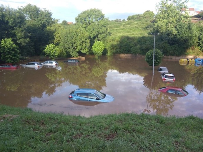 Coches en el parking anegado en Santiallana del Mar 