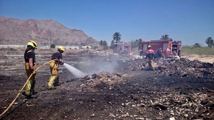 Bomberos extinguen las llamas junto a la N340