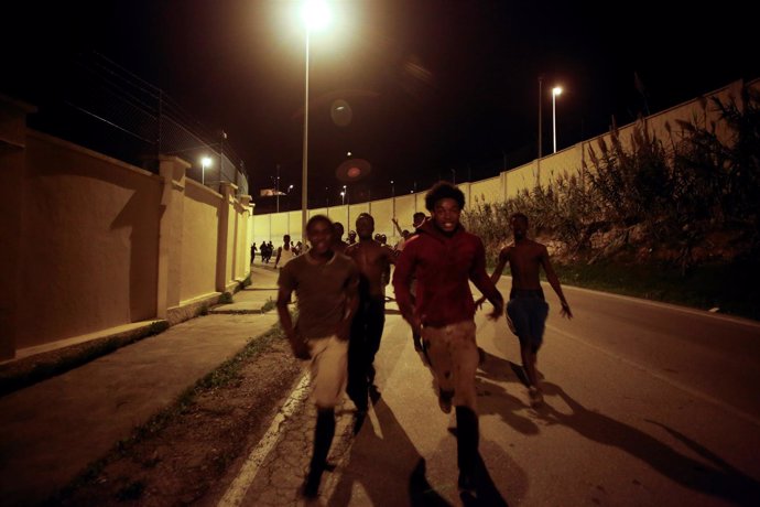 Inmigrantes entran en Ceuta a través de la valla que separa España de Marruecos