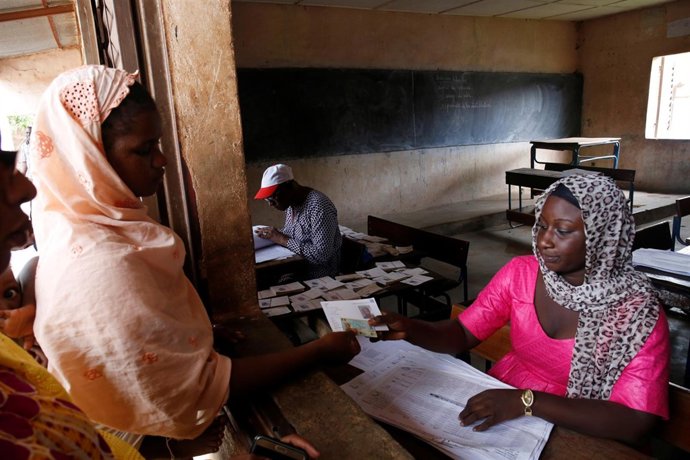 Una mujer recoge su tarjeta de votación en la capital de Malí, Bamako