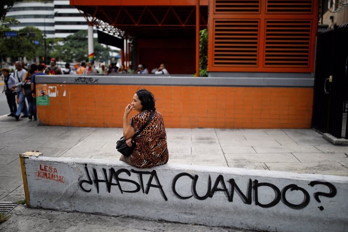 Una mujer espera el autobús tras salir del metro de Caracas por un apagón
