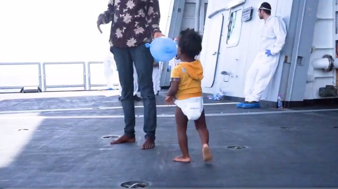 Una niña migrante camina por la cubierta de un barco tras ser rescatada del mar