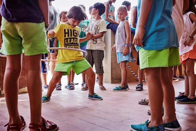 Un niño baila el hula hoop en una colonia urbana de CaixaProinfancia