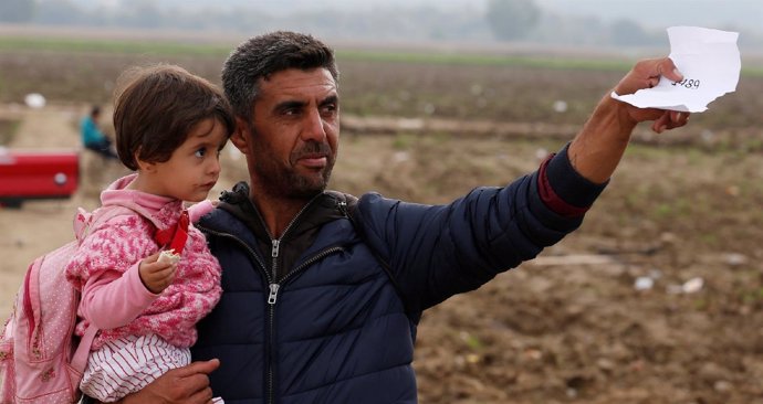 Un refugiado con su hija en brazos