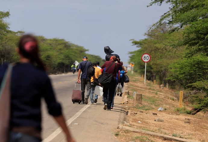 Inmigrantes venezolanos caminan tras entrar en Colombia