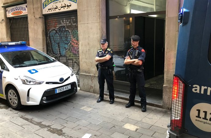 Dos agents de la Guàrdia Urbana de Barcelona custodien un pis del Raval