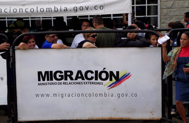 Venezuelans stand in line, outside a migration office, at the border between Ven