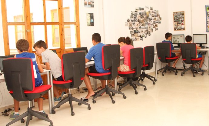 Niños haciendo actividades sobre las TIC en un centro de Guadalinfo
