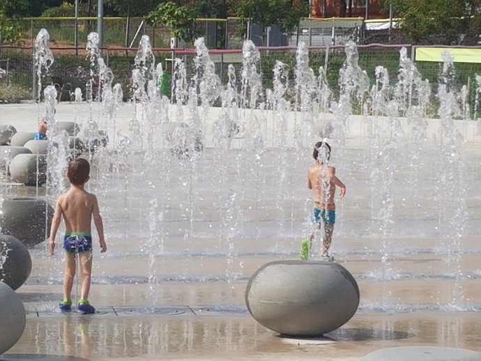 Nens refrescant-se a les fonts del parc Santiburcio de Barcelona