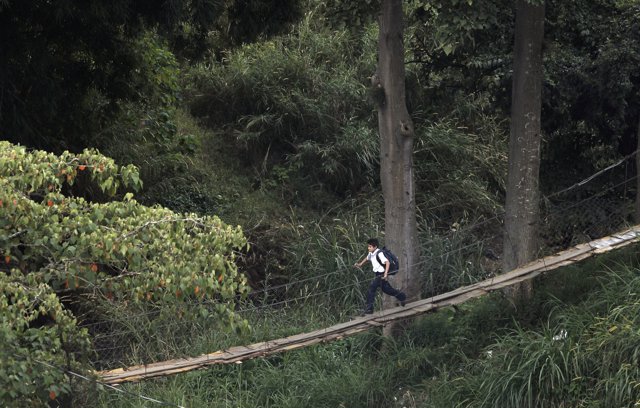 A boy crosses a hanging bridge in the San Francisco slum, near San Jose November