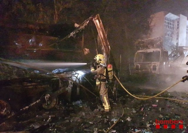 Un bomber apaga l'incendi que ha cremat tres vehicles