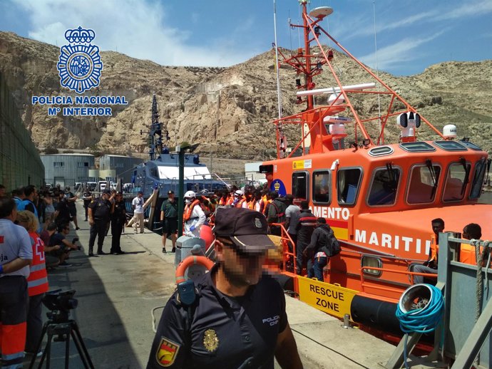 Agentes de la Policía Nacional reciben a los inmigrantes desembarcados hoy 