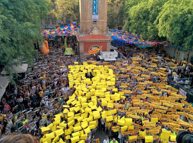 Lazo amarillo formado por personas sujetando pancartas en Gràcia (Barcelona)