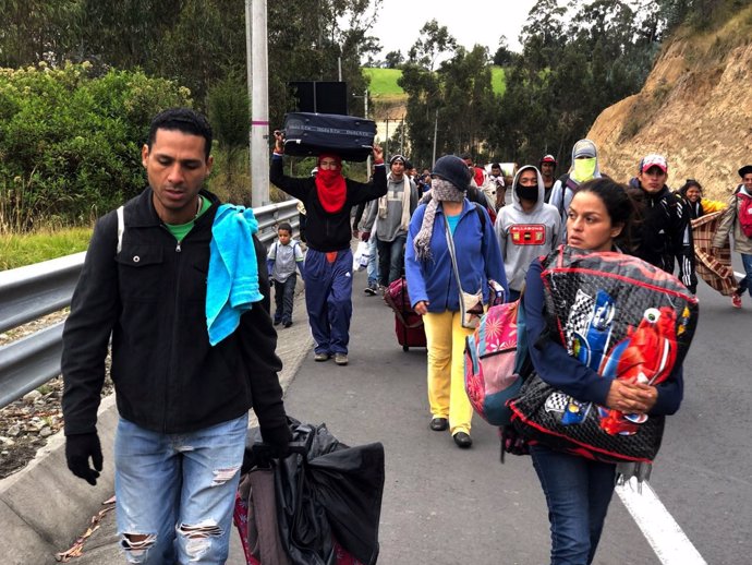 Inmigrantes venezolanos por una carretera ecuatoriana para entrar en Perú