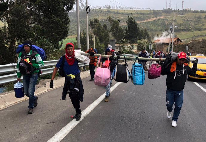 Migrantes venezolanos caminan por una carretera de Ecuador hacia Perú