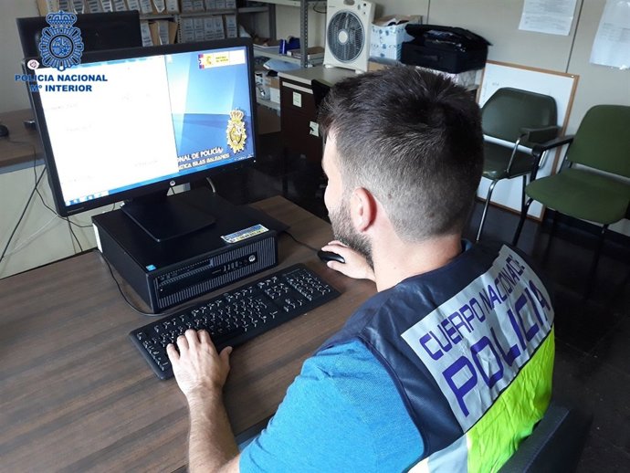 Un policía utilizando un ordenador, hacker, seguridad informática