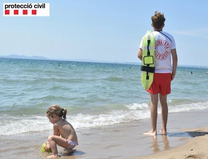 Un socorrista vigila el baño en una playa catalana