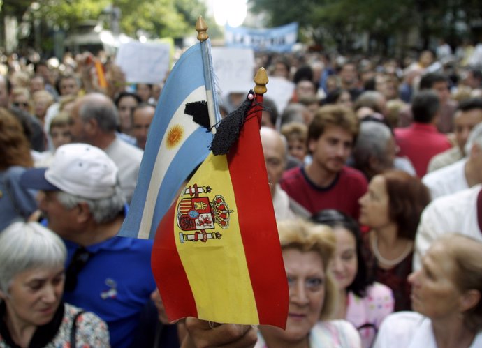 A protester holds Spanish and Argentine flags in Buenos Aires to mourn the victi