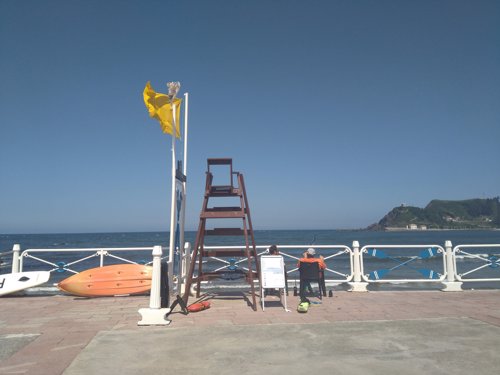 Playa con bandera amarilla (Imagen de archivo)
