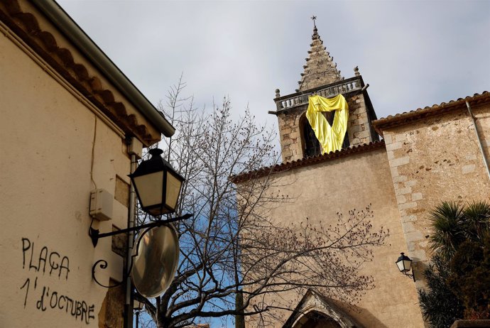 Un lazo amarillo colgando de la iglesia de Aiguaviva (Girona)
