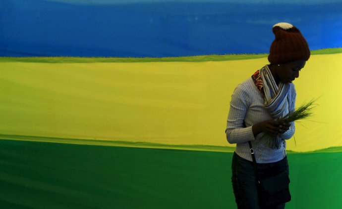Una mujer delante de una bandera de Ruanda