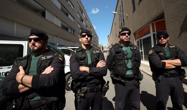 Spanish civil guards block a street next to a Unipost office which was raided in