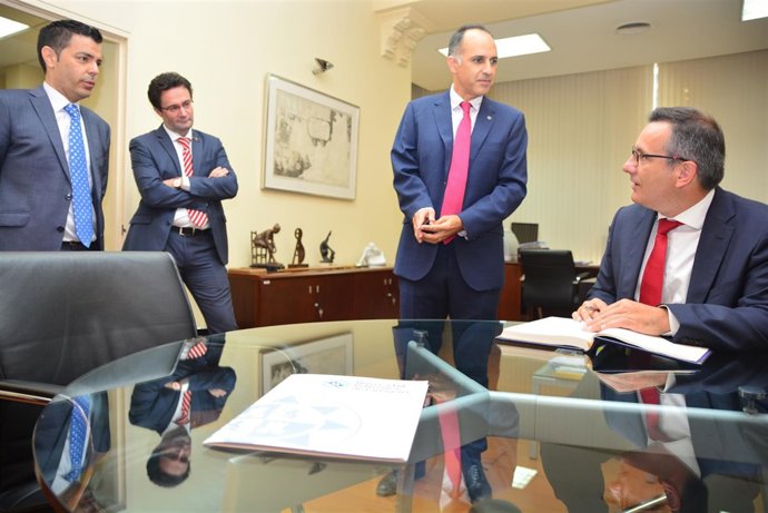 El delegado del Gobierno firma el documento en presencia dle rector