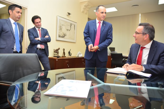 El delegado del Gobierno firma el documento en presencia dle rector