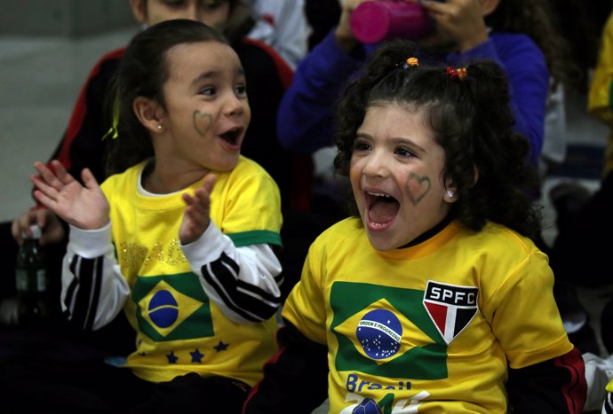 Students watch the broadcast of the World Cup Group E soccer match between Brazi