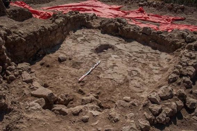 Casa rectangular de esquinas redondeadas con un hogar central construido