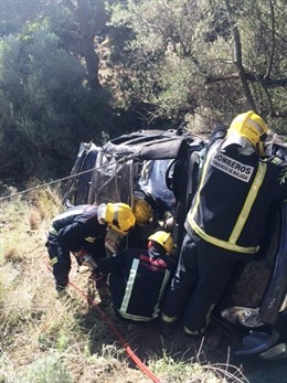 Bomberos rescatan a un conductor tras un accidente de tráfico. 