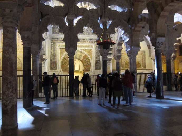 Turistas ante el Mihrab de la Mezquita, del que les separa una valla