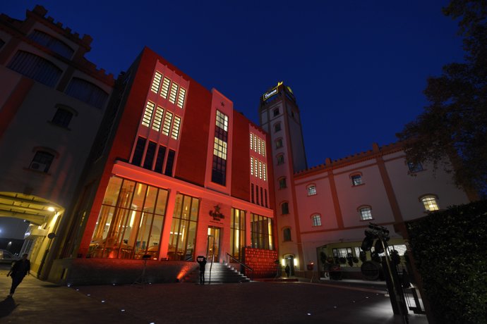 Fachada de la Antiga Fàbrica Estrella Damm iluminada de rojo