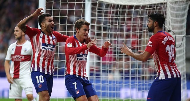 Griezmann celebra con Diego Costa y Correa su gol en el Atlético-Huesca