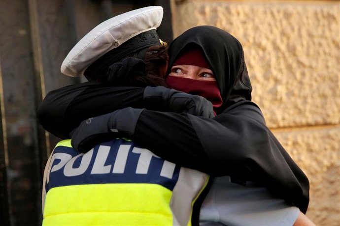 Una policía danesa abraza a una manifestante con niqab en Copenhague