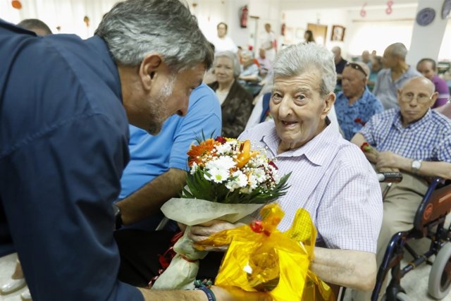 El diputado Ángel Escobar entrega un ramo de flores a Martirio el Día del Mayor.