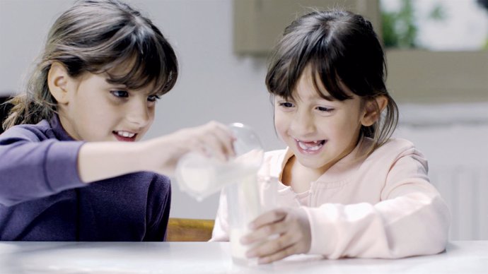 Nenes amb gots de llet.La llet és un dels aliments més sol·licitats per las en