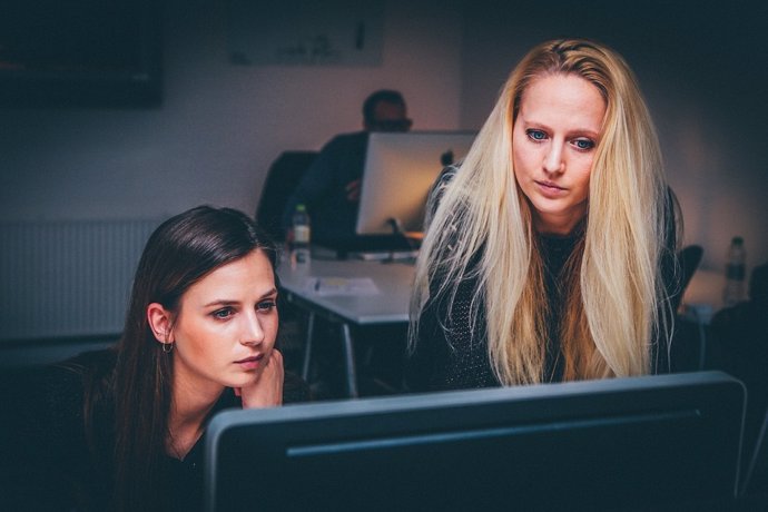 Mujeres consultando un ordenador en el trabajo 
