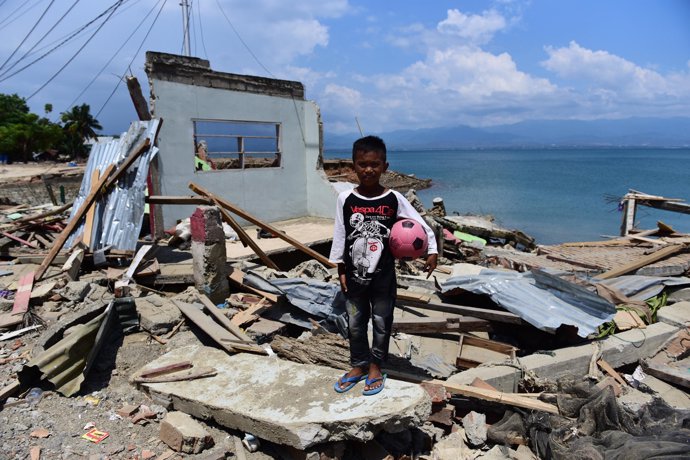 Un niño junto a una vivienda destruida en Palu (Indonesia)
