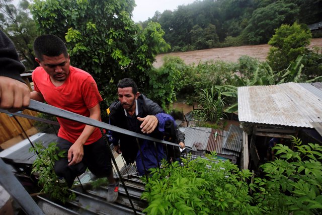 Residents climb stairs nearby the Choluteca river following heavy rains in Teguc