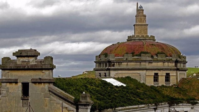 Antigua prisión provincial de A Coruña, al fondo la Torre de Hércules