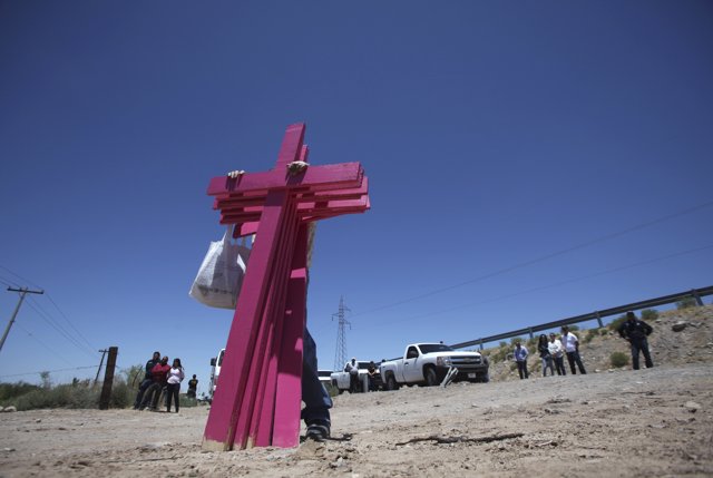 Un hombre sujetando cruces rosas por el abuso sexual en México