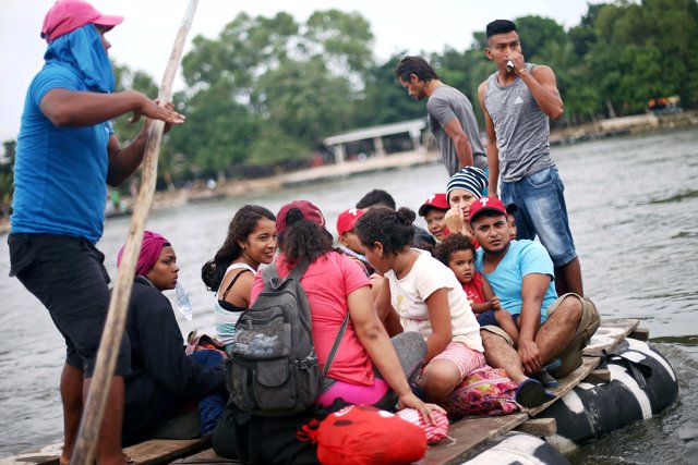 Honduran migrants, part of a caravan trying to reach the U.S., cross the Suchiat