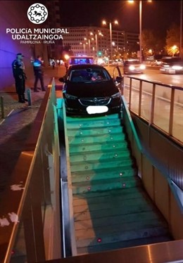 Vehículo encajado en las escaleras de bajada al parking.