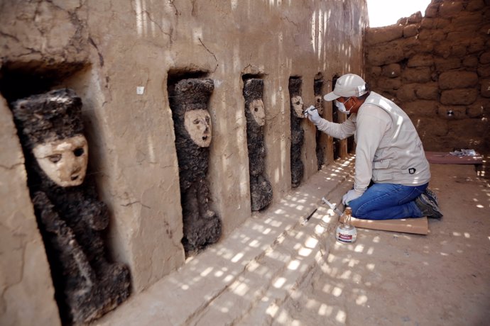 Un arqueólogo limpia una máscara de madera de la cultura Mochica en Trujillo